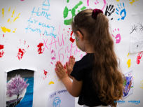Powiększ obraz:dziewczynka odciska dłonie na białym plakacie