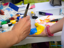 Powiększ obraz:malowanie niebiesko-żóltych barw na dłoni dziecka